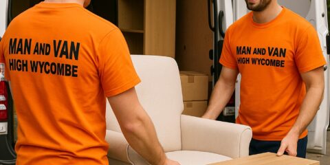 Two professional movers from Man and Van High Wycombe carefully moving furniture from a white van. Both wear bright orange shirts with the company name, symbolising trust, care and efficiency in local removals.